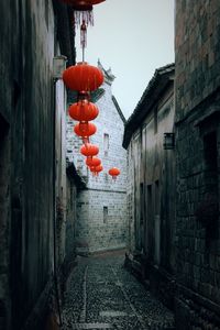Red lanterns hanging on wall by old building