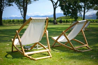 Chairs on field against sky