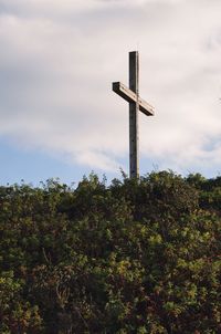 Low angle view of cross on tree against sky