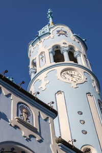 Low angle view of clock tower against blue sky