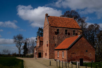 Exterior of house by building against sky