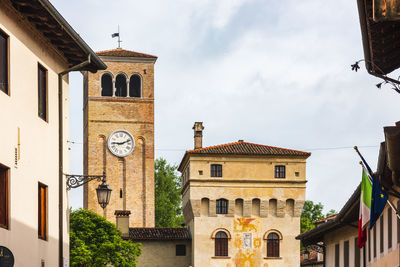 Low angle view of clock tower amidst buildings in city