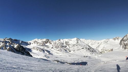 Scenic view of snowcapped mountains against clear blue sky