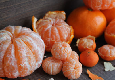 Tangerines large and small peeled on a dark wooden background,  new year's concept. 
