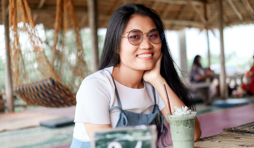 Portrait of smiling young woman on table