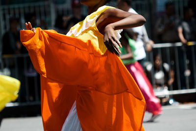 Side view mid section of kids doing traditional dance on road