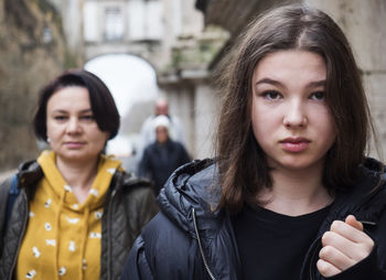 Young teen girl and her mother walking down the city street