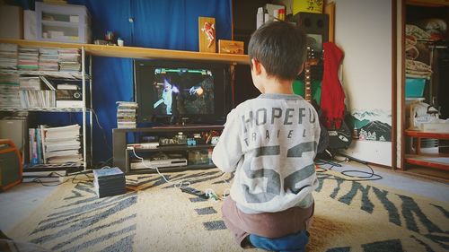 Rear view of boy standing at store