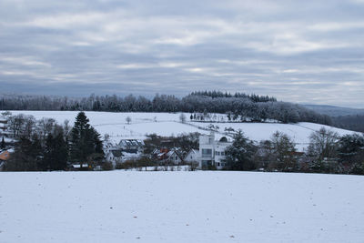 Scenic view of snow covered land against sky