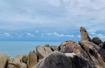 Rock formations by sea against sky