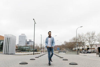 Man commuting in the city, using his kickboard