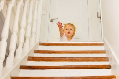 High angle view of cute baby boy sitting on staircase