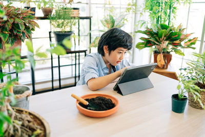 Boy sitting on table at home