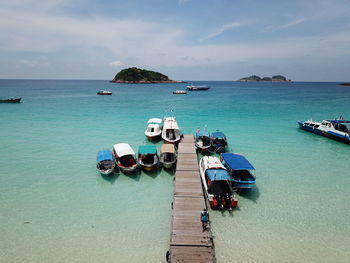 High angle view of boats moored at harbor against sky