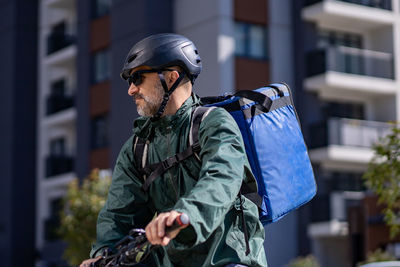 Deliveryman riding electric bicycle in city