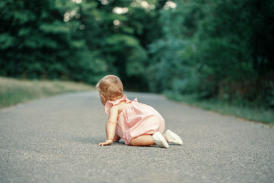 Cute girl crawling on road