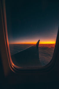 Airplane wing against sky at night