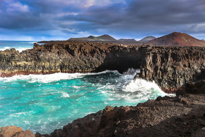 Rock formations in sea against sky