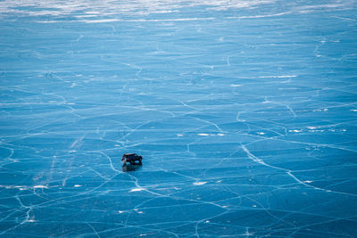 Aerial view of van driving on frozen lake