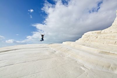 Full length of man jumping in mid-air against sky