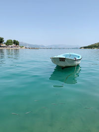 Boats moored in sea against clear sky