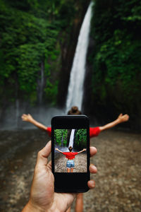 Cropped hands of woman using mobile phone