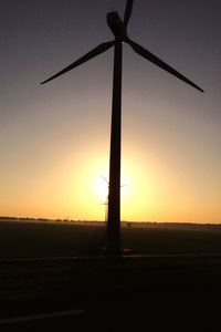 Silhouette of windmill against clear sky at sunset