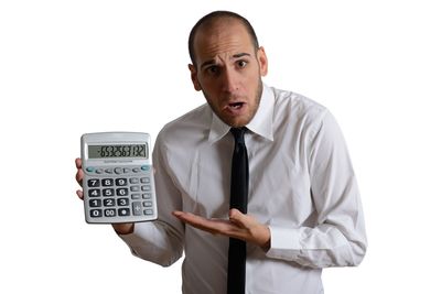 Man holding camera while standing against white background