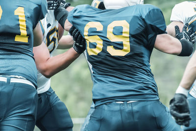 Midsection of people playing american football