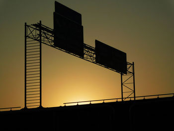 Low angle view of silhouette built structure against sky