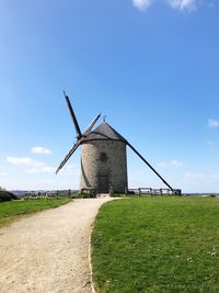 Traditional windmill on field against sky