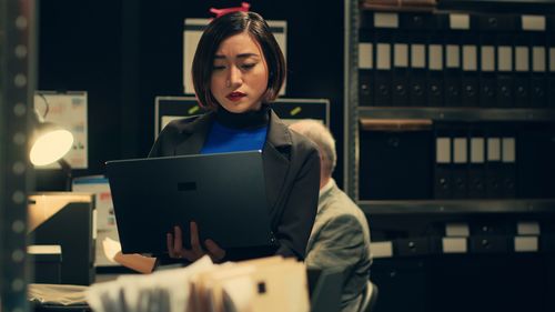 Portrait of young woman using laptop at office