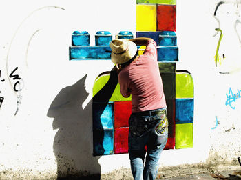 Rear view of man standing against wall