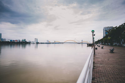 Scenic view of river against sky in city