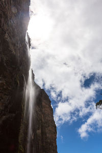 Low angle view of waterfall against sky