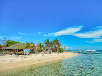 Scenic view of beach against blue sky