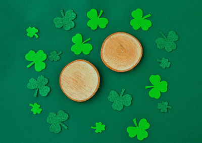 Saint patricks day background with green shamrock laid out next to a wooden saw, a place for text.