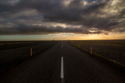 Country road against cloudy sky