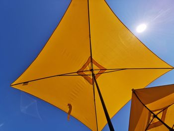 Low angle view of yellow umbrella against sky