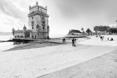 Tourists at belem tower at riverbank