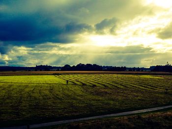 Scenic view of field against cloudy sky