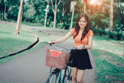 Portrait of smiling young woman on bicycle in city