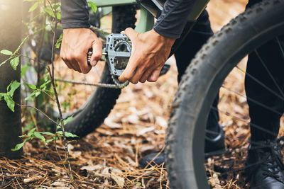 Low section of man riding bicycle on field