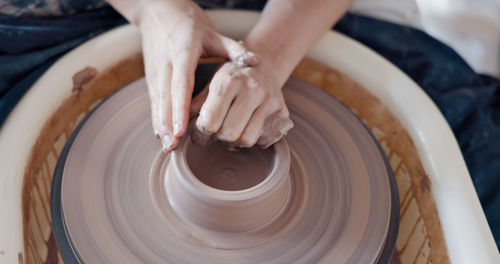 Midsection of man making pottery at workshop