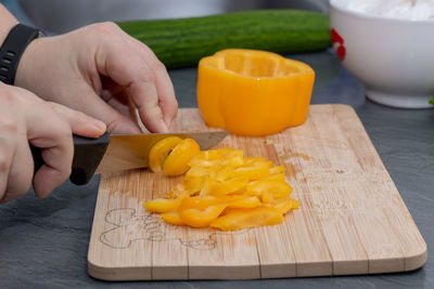 Midsection of person preparing food on cutting board