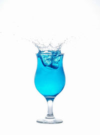 Close-up of drink in glass against white background