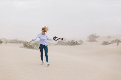 Full length of young woman against clear sky