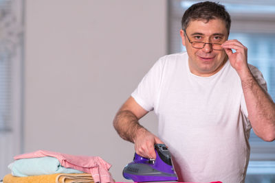 Portrait of man ironing cloth at home