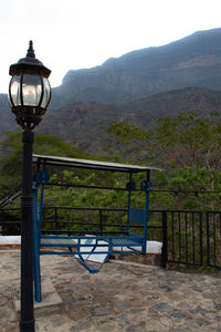 Street light by mountains against sky