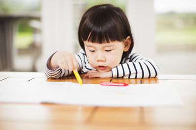 Portrait of cute girl holding table